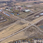 Bridge construction adjacent to the intersection of Highway 22X and James McKevitt Road / Spruce Meadows Way, with nearby stormwater ponds and Spruce Meadows (looking southeast)